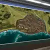 Dense coastal city built on a peninsula with hundreds of brown and orange-roofed buildings.