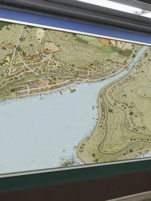 Scattered structures line the eastern shore with wooden piers extending into water.